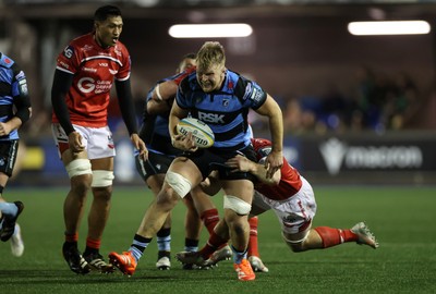 191225 - Cardiff Rugby v Scarlets - United Rugby Championship - Josh McNally of Cardiff is tackled by Kemsley Mathias of Scarlets 