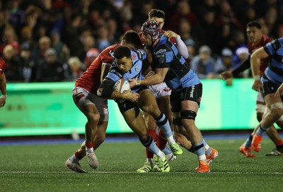 191225 - Cardiff Rugby v Scarlets - United Rugby Championship - Ben Thomas of Cardiff is tackled by Johnny Williams of Scarlets 
