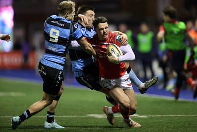 191225 - Cardiff Rugby v Scarlets - United Rugby Championship - Tom Rogers of Scarlets is tackled by Aled Davies and Josh Adams of Cardiff 
