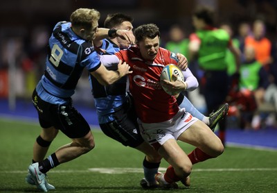 191225 - Cardiff Rugby v Scarlets - United Rugby Championship - Tom Rogers of Scarlets is tackled by Aled Davies and Josh Adams of Cardiff 
