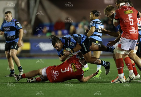 191225 - Cardiff Rugby v Scarlets - United Rugby Championship - Javan Sebastian of Cardiff is tackled by Henry Thomas of Scarlets 