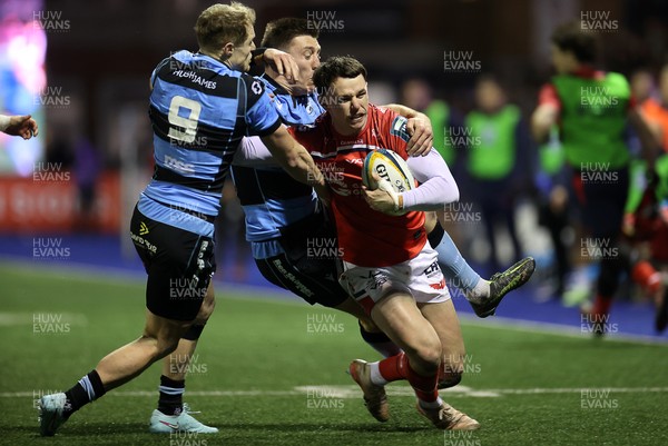 191225 - Cardiff Rugby v Scarlets - United Rugby Championship - Tom Rogers of Scarlets is tackled by Aled Davies and Josh Adams of Cardiff 