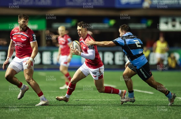 191225 - Cardiff Rugby v Scarlets, United Rugby Championship - Tom Rogers of Scarlets takes on Liam Belcher of Cardiff Rugby