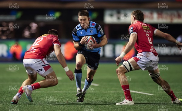 191225 - Cardiff Rugby v Scarlets, United Rugby Championship - Josh Adams of Cardiff Rugby takes on Johnny Williams of Scarlets and Max Douglas of Scarlets