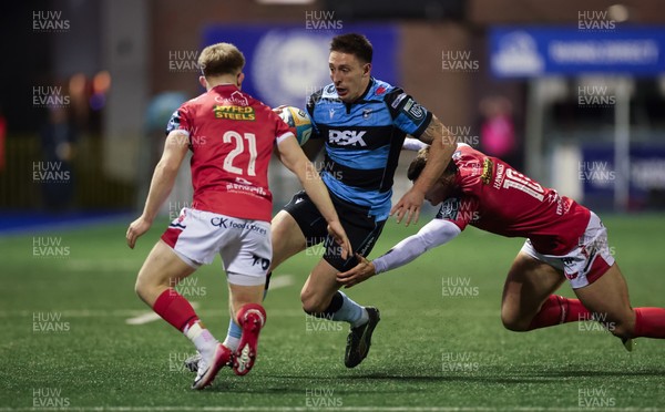 191225 - Cardiff Rugby v Scarlets, United Rugby Championship - Josh Adams of Cardiff Rugby takes on Joe Hawkins of Scarlets and Archie Hughes of Scarlets