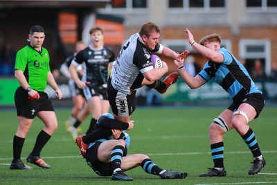 270124 - Cardiff v Bridgend - Indigo Group Premiership - Evan Yeardley of Bridgend Ravens is tackled by Tom Habberfield of Cardiff