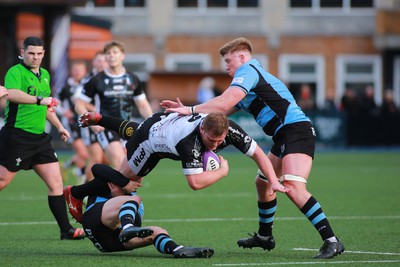 270124 - Cardiff v Bridgend - Indigo Group Premiership - Evan Yeardley of Bridgend Ravens is tackled by Tom Habberfield of Cardiff