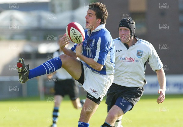 270503 - Cardiff v Bridgend - Welsh Premiership - Bridgend's Emyr Lewis collects high ball as Matt Allen closes in