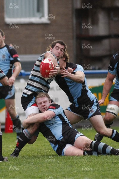 261209 - Cardiff RFC v Glamorgan Wanderers RFC - Principality Premiership - Glamorgan Wanderers' Dafydd Hewitt looks to offload as Rhys James hangs on in the tackle