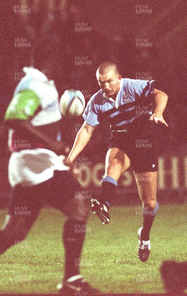 091096 - Cardiff v Harlequins - Lee Jarvis of Cardiff kicks over Peter Mensah