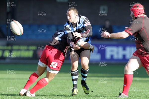 271012 Cardiff RFC v Llanelli RFC - Principality Building Society Premiership - Cardiff's Gareth Davies offloads during a tackle from Craig Hawkins of Llanelli 