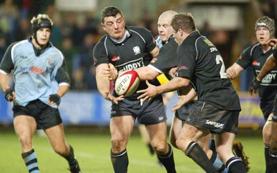 280203 - Cardiff v Neath - Welsh Premiership - Neath's Rowland Phillips passes to Steve Jones as John Yapp tackles