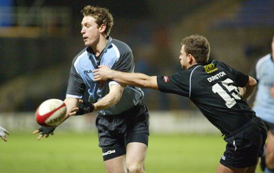 280203 - Cardiff v Neath - Welsh Premiership - Cardiff's Jamie Robinson feeds the ball out as Adrian Durston closes in