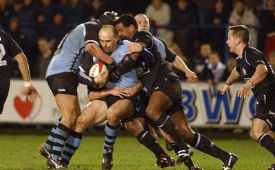 280203 - Cardiff v Neath - Welsh Premiership - Cardiff's Pieter Muller keeps possession as Alfie Mocelutu closes in