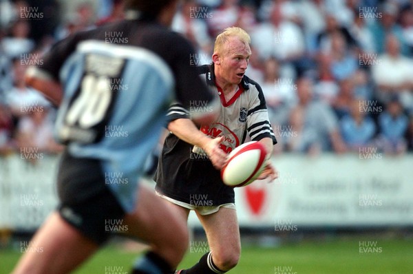 300503 - Cardiff v Pontypridd - Welsh Premiership - Neil Jenkins feeds the ball out as his opposite number Nicky Robinson covers