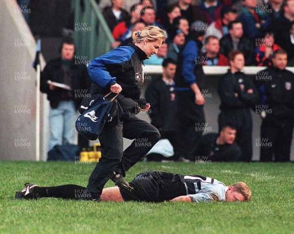 131297 - Cardiff v Swansea -  Injured Gwyn Jones of Cardiff lies motionless on the ground as physio Jane Parker rushes to his aid