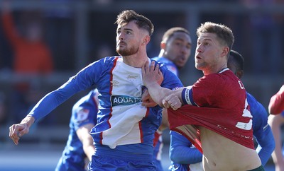 050425 - Carlisle United v Newport County - Sky Bet League 2 - Joe Hugill of Carlisle clutches James Clarke of Newport to prevent him closing in on header