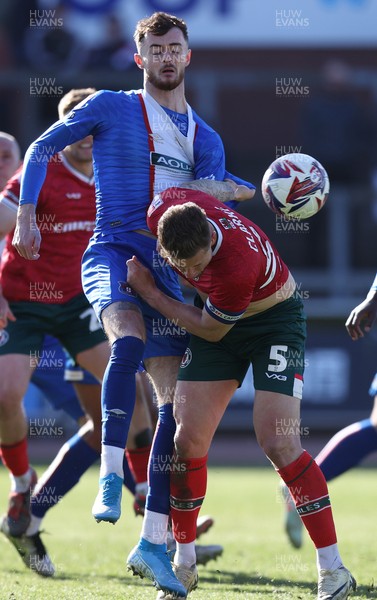 050425 - Carlisle United v Newport County - Sky Bet League 2 - Joe Hugill of Carlisle clutches James Clarke of Newport to prevent him closing in on header