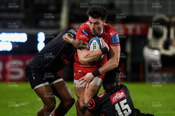 110322 - Cell C Sharks v Scarlets - United Rugby Championship - Johnny Williams of Scarlets is tackled by Aphelele Fassi of Sharks (15)