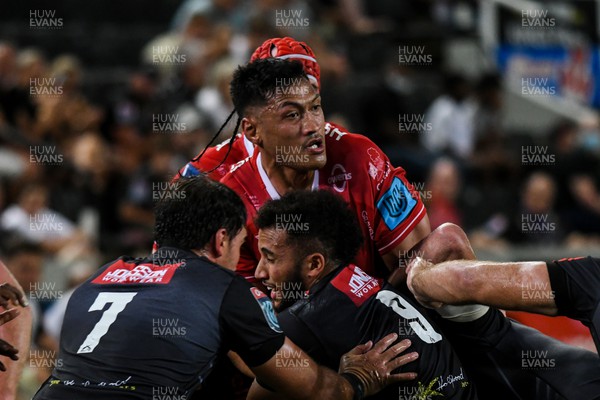 110322 - Cell C Sharks v Scarlets - United Rugby Championship - Sam Lousi of Scarlets is tackled by Henco Venter and Jaden Hendrikse of Sharks