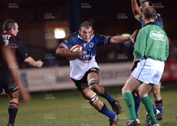 281103 - Celtic Warriors v Edinburgh - Warriors' Robert Sidoli looks as though he holding off the referee as he makes his way thro'