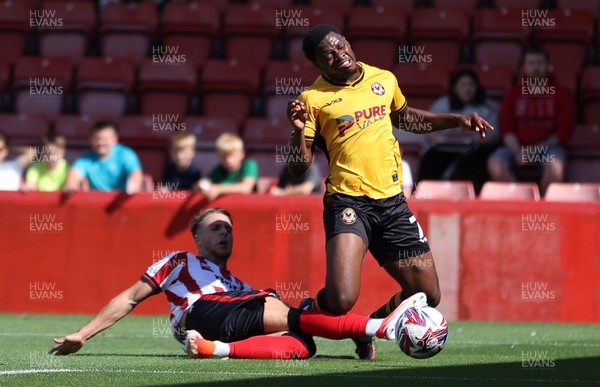 100824 - Cheltenham Town v Newport County, SkyBet League Two - Bobby Kamwa of Newport County is given a penalty from this tackle by Lewis Payne of Cheltenham Town 