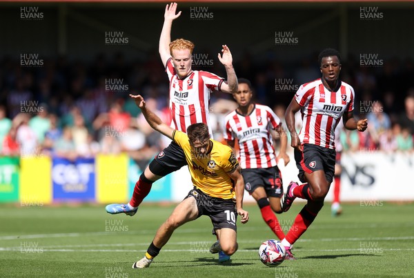 100824 - Cheltenham Town v Newport County, SkyBet League Two - Oliver Greaves of Newport County is tackled by Ryan Haynes of Cheltenham Town 