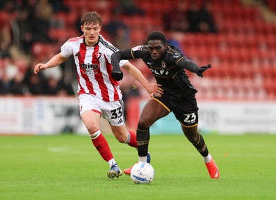 241026 Cheltenham Town v Newport County, EFL Sky Bet League 2 -  Michael Adu-Poku of Newport County gets between Freddy Willcox of Cheltenham Town and Ben Stevenson of Cheltenham Town