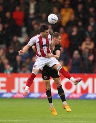 241026 Cheltenham Town v Newport County, EFL Sky Bet League 2 - Charlie McCann of Cheltenham Town and Ciaran Brennan of Newport County compete for the ball