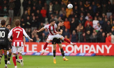 241026 Cheltenham Town v Newport County, EFL Sky Bet League 2 - Charlie McCann of Cheltenham Town and Ciaran Brennan of Newport County compete for the ball