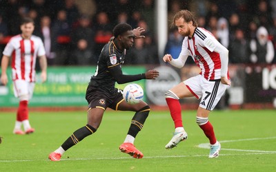 241026 Cheltenham Town v Newport County, EFL Sky Bet League 2 - Michael Adu-Poku of Newport County and Ben Stevenson of Cheltenham Town compete for the ball