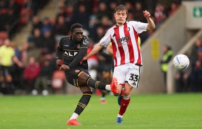 241026 Cheltenham Town v Newport County, EFL Sky Bet League 2 - Michael Adu-Poku of Newport County shoots at goal as Freddy Willcox of Cheltenham Town closes in