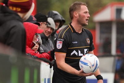 241026 Cheltenham Town v Newport County, EFL Sky Bet League 2 - \a Cheltenham Town supporter pulls the shirt of Cameron Norman of Newport County as he goes to take a throw in