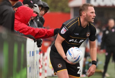241026 Cheltenham Town v Newport County, EFL Sky Bet League 2 - \a Cheltenham Town supporter pulls the shirt of Cameron Norman of Newport County as he goes to take a throw in