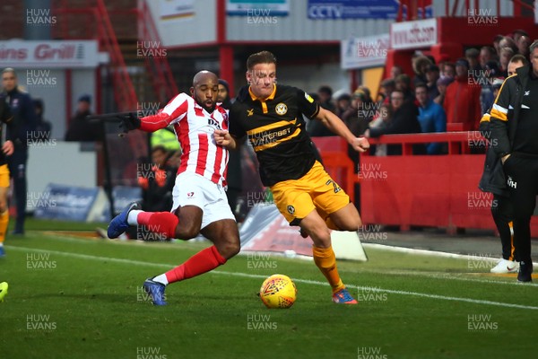241118 - Cheltenham Town v Newport County - EFL SkyBet League 2 - Cameron Pring of Newport County is tackled by Nigel Atangana of Cheltenham Town
