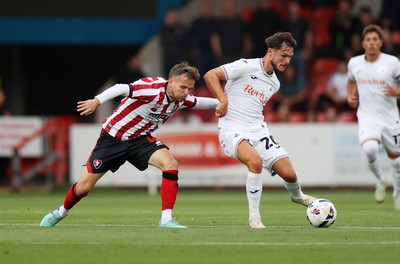 230725 - Cheltenham Town v Swansea City - Pre Season Friendly - Liam Cullen of Swansea City is challenged by Liam Kinsella of Cheltenham Town 