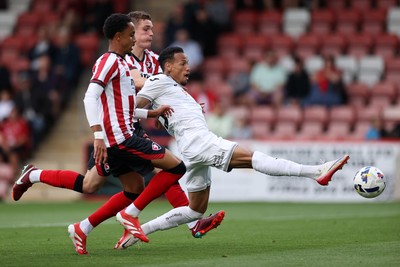 230725 - Cheltenham Town v Swansea City - Pre Season Friendly - Ronald of Swansea City stretches to get to the ball