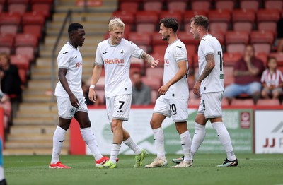 230725 - Cheltenham Town v Swansea City - Pre Season Friendly - Swansea celebrate after Cheltenham score an own goal