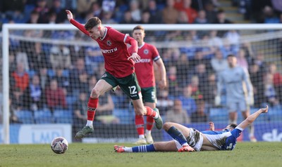 080325 - Chesterfield v Newport County - Sky Bet League 2 - Joe Thomas of Newport leaps over Armando Dobra of Chesterfield