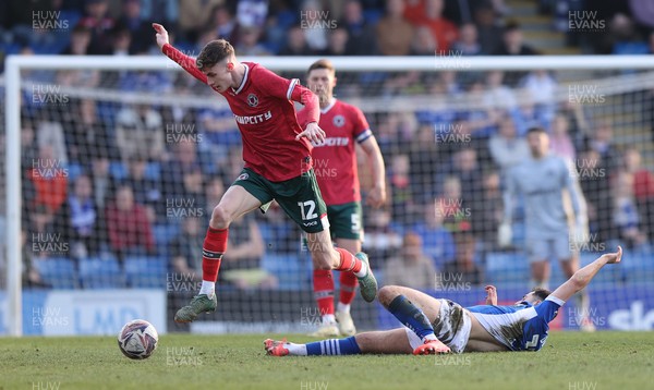 080325 - Chesterfield v Newport County - Sky Bet League 2 - Joe Thomas of Newport leaps over Armando Dobra of Chesterfield