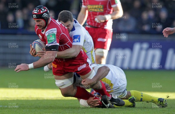 071213 - Clermont Auvergne v Scarlets - Heineken Cup - George Earle of Scarlets is tackled by Benjamin Kayser and Fritz Lee of Clermont 