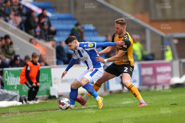 010423 - Colchester United v Newport County - Sky Bet League 2 - Connor Wood of Colchester United is under pressure from Cameron Norman of Newport County