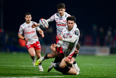130326 - Connacht v Scarlets - United Rugby Championship - Joe Roberts of Scarlets offloads the ball to team-mate Ioan Jones, centre, as he is tackled by Cathal Forde of Connacht