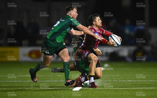 211022 - Connacht v Scarlets - BKT United Rugby Championship - Steff Evans of Scarlets is tackled by David Hawkshaw, left, and John Porch of Connacht