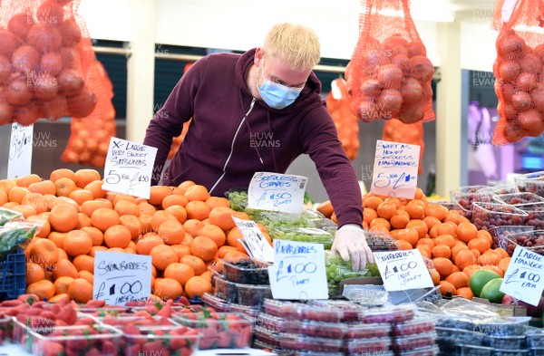 230320 - Coronavirus Outbreak - A man on his fruit and vegetable stall at Cardiff Market in Cardiff City centre during Monday morning