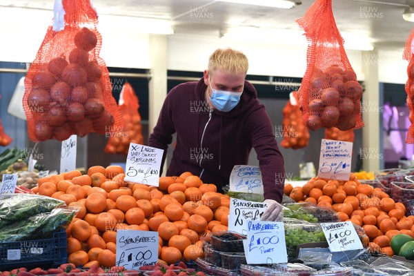 230320 - Coronavirus Outbreak - A man on his fruit and vegetable stall at Cardiff Market in Cardiff City centre during Monday morning