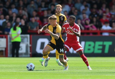 080825 - Crawley Town v Newport County, EFL Sky Bet League 2 - Kai Whitmore of Newport County holds off Reece Brown of Crawley Town