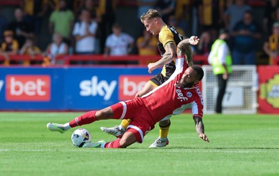080825 - Crawley Town v Newport County, EFL Sky Bet League 2 - Kai Whitmore of Newport County is tackled by Jay Williams of Crawley Town