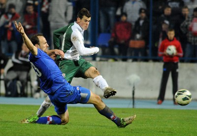 061012 - Croatia v Wales - World Cup QualifierWales' Gareth Bale offloads a shot before being tackled by Gordon Schildenfeld 
