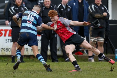 250323 - Cross Keys v Ystrad Rhondda - WRU Championship Cup Semi Final - Josh Williams of Ystrad Rhondda hands of Walker Price of Cross Keys 